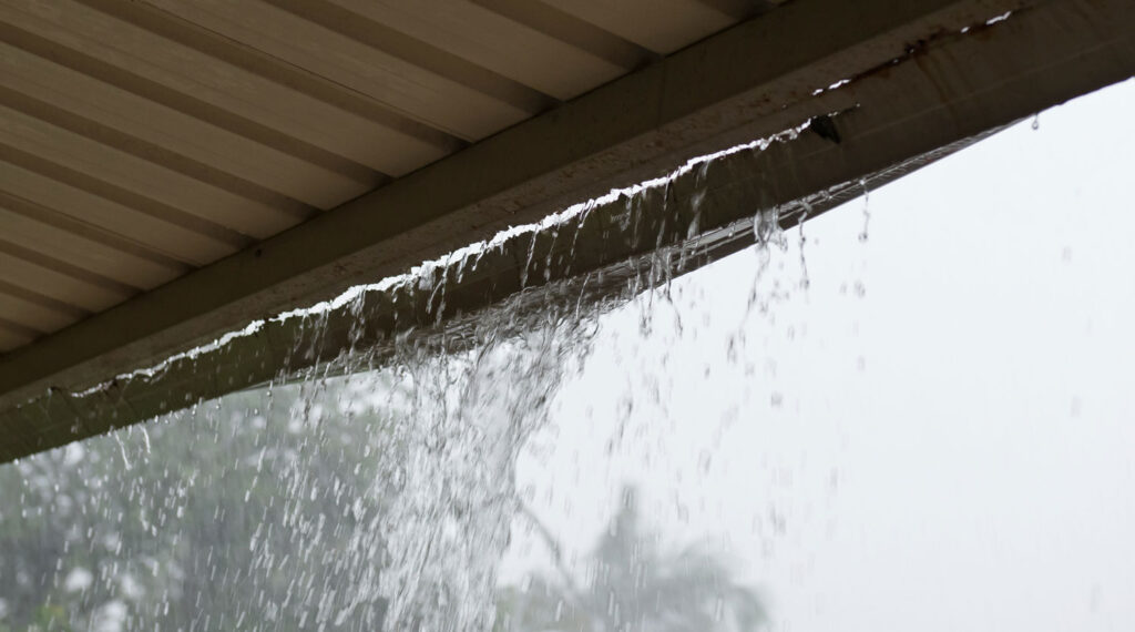 Rain overflowing residential gutter.